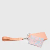 Billetera tipo set compuesta por un monedero liso color salmón y un tarjetero estampado con diseño de hojas en tonos salmón y celeste, unidos por una correa de muñeca de cinta técnica color salmón.