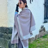 Ruana color beige con borde gris.