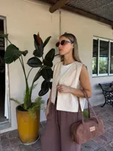 Chaleco marrón con bordados florales en color crema en los bordes y el frente. Presenta un diseño sin mangas con escote en V.