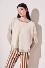 Sweater de punto color beige con mangas marrones y cuello y ruedo en azul marino.