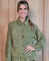 Sobrecamisa de pana color verde oliva, con cuello clásico, cierre frontal de botones, mangas largas con puños abotonados y detalle de volado en el ruedo.