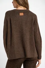 Sweater de tejido de punto color bordó, con cuello redondo, mangas largas y puños acanalados. Presenta un diseño de corte recto y textura suave.