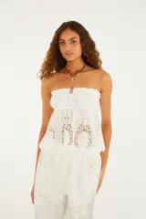 Top strapless blanco de algodón con diseño calado, detalles de encaje y banda elástica fruncida en el escote y bajo el busto, con estilo babydoll.