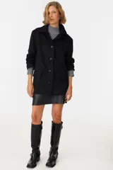 Tapado negro con cuello solapa, de corte recto y largo hasta la rodilla.