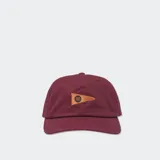 Gorro de béisbol ajustable Stance, color rojo oscuro (Rebel Rose), con visera curva. Presenta un parche frontal con forma de banderín triangular de color marrón claro con un logo bordado en el centro.