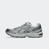 Championes Asics modelo Gel 1130, color blanco con detalles plateados y verde oscuro. Diseño retro inspirando en el running con tecnología GEL en el talón.