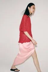 Top rojo de punto con textura efecto arrugado, cuello redondo y mangas cortas holgadas.