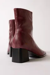 Bota de caña media con textura de reptil en color negro, punta cuadrada y taco bloque.