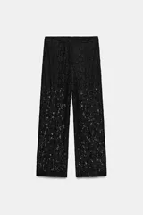 Pantalón de tiro alto confeccionado en encaje negro con diseño floral, de corte recto y largo cropped. Cuenta con forro interior a tono y cierre frontal con cremallera y ganchos metálicos.