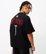 Remera boxy de algodón negro con mangas cortas y cuello redondo, con bordados en rojo y blanco con tipografía japonesa y diseño gráfico en la espalda.