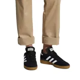 Championes Adidas Busenitz negros con las tres tiras blancas y suela marrón.