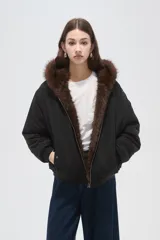 Campera bomber negra con cuello de piel sintética marrón, cierre frontal con cremallera y puños elásticos.