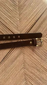 Cinturón de cuero marrón con hebilla metálica dorada de diseño rectangular.