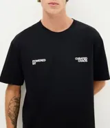 Remera de algodón con corte relajado, cuello redondo y mangas cortas. Presenta un estampado gráfico en la espalda con diseño de tocadiscos y tipografía estilo urbano.