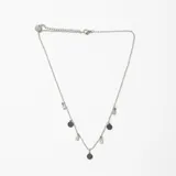 Colgante de cadena fina de acero con dijes intercalados de círculos planos y cristales en forma de gota.