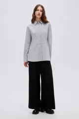 Camisa de algodón a rayas grises y blancas, de corte holgado, con cuello camisero, manga larga y cierre frontal de botones.