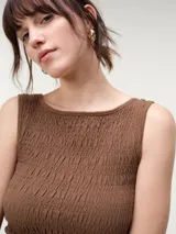 Musculosa de algodón color negro con escote bote, diseño con nido de abeja elástico y terminación con pequeño vuelo en el ruedo.