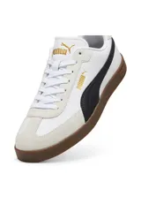 Championes deportivos Puma modelo Club II Era, de color blanco con detalles en negro, tapín de gamuza gris claro en la puntera y suela de goma marrón.