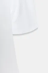 Camiseta blanca de algodón compacto, corte slim fit, con cuello redondo y manga corta abullonada.