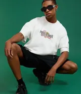 Remera blanca de corte oversized con mangas cortas y estampado frontal con la frase "Born to Drift".