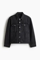 Campera trucker de denim de algodón rígido, color negro gastado, con cuello clásico, cierre frontal de botones metálicos, bolsillos con solapa en el pecho y bolsillos ribeteados laterales.
