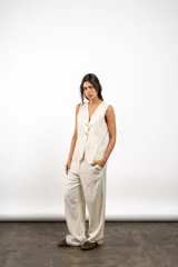 Pantalón de lino color crema, de corte recto y holgado, con cintura elástica y bolsillos laterales.