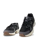 Championes New Balance modelo 530, color negro y gris con detalles en blanco y suela marrón. Confeccionados en malla y gamuza, con cordones negros y el logo "N" en los laterales.