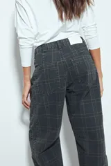 Pantalón de corte barrel con diseño a cuadros, tiro medio y pierna curva. Confeccionado en denim de algodón, presenta una estructura relajada y contemporánea.