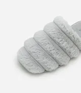 Pantufla cerrada de diseño acolchado con gajos, confeccionada en tejido de textura felpuda suave, con suela de goma termoplástica.