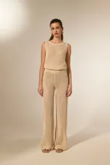 Pantalón largo de tejido en red con lentejuelas, color beige, de tiro bajo y corte holgado.