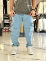 Pantalón cargo de jean azul con múltiples bolsillos en los laterales y diseño holgado.