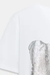 Camiseta blanca de manga corta y cuello redondo, con detalle de estampa central metalizada de efecto texturizado y diseño regular fit.