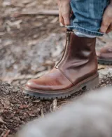Bota de cuero marrón con suela de goma y cierre frontal con cremallera.