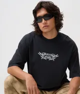 Remera boxy de algodón negro con cuello redondo, mangas cortas y estampa frontal blanca con diseño "Burning Eclipse".