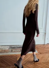 Vestido midi marrón oscuro de corte recto y escote en V, con mangas largas y un cinturón fino con hebilla metálica dorada en la cintura.