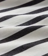 Vestido midi de viscosa con estampado a rayas verticales en blanco y negro, escote en V, mangas cortas y lazo ajustable en la cintura con cordón y borlas.