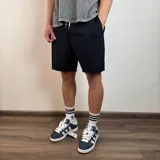 Short de algodón negro con cintura elástica, cordón ajustable y bordes inferiores con acabado desflecado.