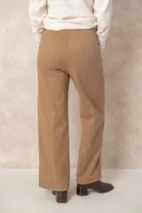 Pantalón de corte recto con bolsillos laterales, confeccionado en un tejido con acabado tipo gamuza que aporta textura y calidez.