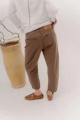 Pantalón de denim oscuro con tiro bajo y calce relajado. Presenta un cierre frontal con botones a la vista y costuras en contraste.