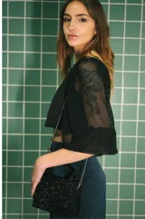 Minifalda azul con brillos, corte pareo y flecos negros en el ruedo.