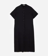 Vestido chemise midi color negro confeccionado en viscosa, de corte recto y holgado. Cuenta con cuello camisero, mangas cortas y cierre frontal con botones al tono.