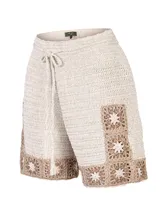 Short tejido a crochet de color beige con detalles geométricos en tono marrón en el borde inferior y lateral. Cuenta con cintura elástica y cordón ajustable con borlas.