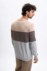 Buzo de punto con diseño de franjas horizontales en tonos beige, marrón y gris, de cuello redondo y manga larga con puños y ruedo acanalados.
