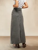 Falda larga de denim en color gris con efecto lavado, de corte recto y tiro alto. Presenta costuras verticales decorativas y cierre frontal con botón y cremallera.
