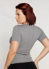 Camiseta deportiva entallada color coral, de manga corta y escote en V. Presenta cortes en el frente y en la espalda.