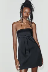 Vestido mini satinado negro con escote palabra de honor y detalle de lazo en el frente.