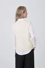 Chaleco de punto gris con escote en V, cierre frontal de botones y dos bolsillos delanteros con terminación acanalada.