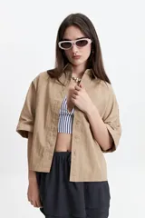 Camisa color beige de manga corta con cuello clásico y corte oversize.