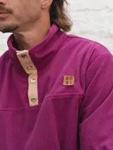 Buzo de pana color beige con cuello polo abotonado y bolsillo en el pecho.