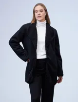 Cárdigan largo reversible color blanco. Un lado es de sherpa y el otro capitoneado. Tiene bolsillos delanteros.